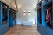 © Paul Phillips/Stocksy - Modern dressing area in a renovated barn. Bathtub at the far end.