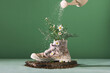 © Marc Tran/Stocksy - Watering a flower in an old boot