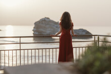 Young Woman, Wearing  Red Dress, Enjoying Sea Sunset View. 