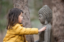 Child Outside With Buddha Statue