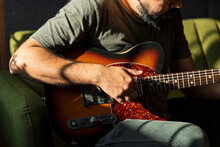 Close Up On The Hands Of A Man Playing An Electric Red Guitar