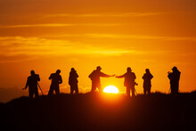 A Group Of Photographers Capture Sunrise. 