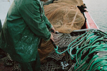 Hands Of A Fisherman Preparing Nets On A Boat