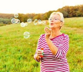 Wall Mural - woman outdoor senior elderly happy fun retirement vitality bubble soap blowing active old nature mat