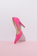 © Jelena Sijak/Stocksy - Pink high heel against a pastel wall.