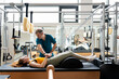 © Santi Nuñez/Stocksy - Young woman doing exercises on pilates reformer