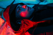 © Producciones Visualix/Stocksy - Woman lying in colored lights and laser lights