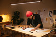 © BONNINSTUDIO/Stocksy - Hipster drawing sketch in home office at night