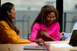© Guille Faingold/Stocksy - Diverse business women laughing during overtime at office