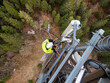 © Jelena Jojic Tomic/Stocksy - A technician on a telecommunication tower, 5G fiber optic antenna