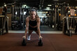 © Juan Algar - Athletic woman using kettlebells while doing plank in gym