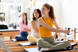 © Santi Nuñez/Stocksy - Women's team doing exercises on pilates machine