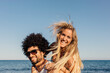 © VICTOR TORRES/Stocksy - Multi-ethnic couple doing piggyback at the beach