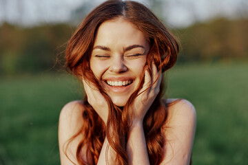 portrait of a young redheaded woman looking into the camera and smiling, close-up portrait of a laug