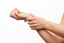 Cropped Shot Of A Young Woman Holding A Wrist In Her Hand Isolated On A White Background. Wrist Injuries, Arm Pain, Carpal Tunnel Syndrome, Neuralgia. Dislocated Wrist. Medical Concept
