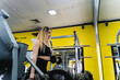 A young woman is working out in the gym during the day