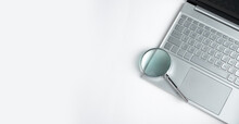 Technology Banner With Laptop Keyboard And Magnifying Lens With Copy Space For Text. High Quality Photo