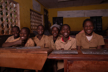 Wall Mural - A group of six african pupils sitting at school desks with their blackboards