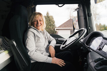 Wall Mural - Caucasian mid age woman driving truck. trucker female worker, transport industry occupation 