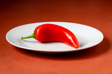 One Red Chili Pepper On White Plate