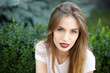 © malinaphoto - Portrait of a girl in a summer park, on a walk against the backdrop of greenery.