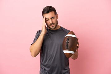 Wall Mural - Young caucasian man playing rugby isolated on pink background with headache