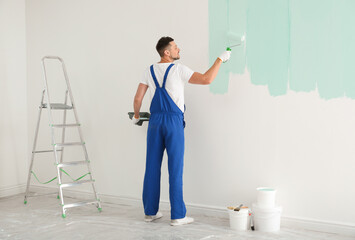 Wall Mural - Man painting wall with light blue dye indoors