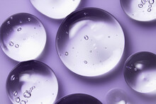 Liquid Serum Gel Texture, Oil Drops On Lavender Color Background. Clear Skincare Cosmetic Product Swatch With Bubbles Closeup