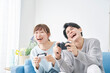 © siro46 - カップル　テレビゲームで遊ぶ　リビング