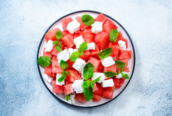Wall Mural - Refreshing summer juicy Watermelon salad with feta cheese and fresh mint, gray table background, top view, copy space
