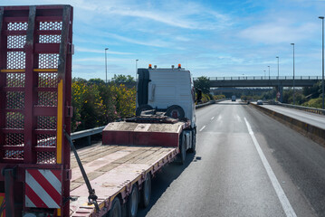 Wall Mural - Truck with a special semi-trailer for the transport of heavy machinery circulating on the highway.Oversize.