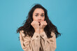 © Prostock-studio - Frightened scared young european brunette female in casual presses her fists to her face, look at camera