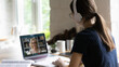 © fizkes - Young student girl in wireless headphones making video call, consulting tutor online, using laptop, watching class, webinar, talking to teacher, discussing study research project
