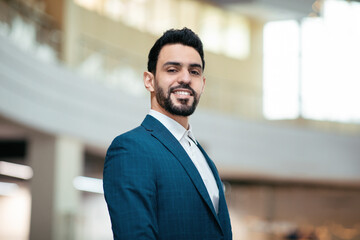 Wall Mural - Smiling confident attractive young arab guy, general manager with beard in suit looks at camera