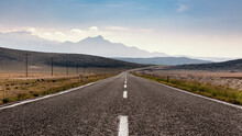 An Empty Highway And Mountains In Perspective View