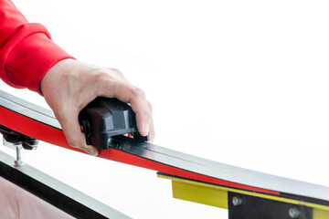 Canvas Print - Serviceman in ski service cuts the structure on the sliding surface of a cross-country ski by knurling