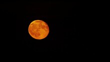 A Full Blood Red Moon Is Floating Against The Black Sky. Time Lapse. Satellite Of The Planet Earth Close-up