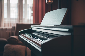 Wall Mural - Electronic piano in the interior of the room on a blurred background.