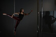 © alexkich - The dancer on the pylon in the studio. Girl doing exercises on a sports equipment.