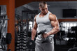 © nikolas_jkd - Muscular man working out in gym doing exercises with dumbbells, strong male