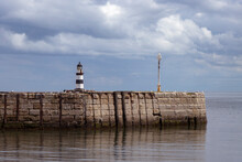 Iconic Striped Seaham Lighthouse On Sea Wall With Cloud Reflections
