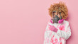 Shocked curly woman wears respirator and chemical suit involved in cleaning operation points away on copy space against pink background tells about protection against coronavirus and flu viruses