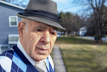 Caucasian Male Senior Adult With A Fedora Hat And Blue Diamond Sweater Vest And Tie