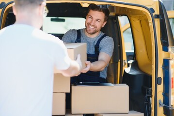 Wall Mural - Courier service for the delivery of goods. Express service a man in a uniform delivers boxes. The employee carries the order home to the client.