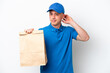 © luismolinero - Young Brazilian man taking a bag of takeaway food isolated on white background having doubts