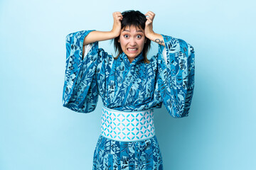 Wall Mural - Young woman wearing kimono over isolated blue background doing nervous gesture