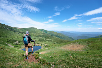 Wall Mural - Active lifestyle. Traveling, hiking and trekking concept. Young man with backpack in the Carpathian mountains.