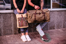 Woman And Man Holding Canvas Bags. Backpack And Duffel Canvas Bag