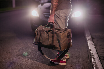 Cropped photo of a well-dressed man with a duffel bag