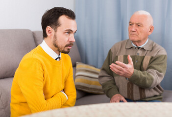 Wall Mural - Old father is serious conversation with his son at home